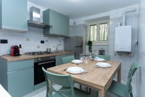 Promo Natale, Esclusiva Struttura Fronte Mare, Vicino al Centro Città في بيسكارا: مطبخ مع طاولة خشبية ودواليب زرقاء