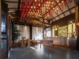 Una habitación con un banco y candelabros en un edificio. en Lijiang Ancient Town Landscape Garden Hotel 山水爱斯花园酒店, en Lijiang 97 fotos más