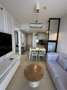 un salon avec un canapé et une table dans l'établissement unixx seaview, à Pattaya (sud)