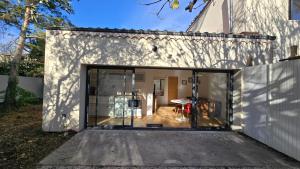 阿维尼翁Le MazeL, meublé de tourisme 2 à 4 personnes的白色房子上的大型推拉玻璃门