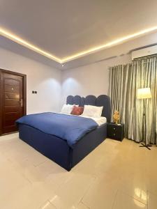 a bedroom with a large blue bed in a room at Luxury Apartment in Abuja