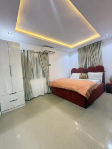 a bedroom with a bed and a dresser and curtains at Luxury Apartment in Abuja