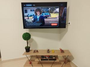 a tv hanging on a wall with a coffee table at Comfort Holidays in Messini