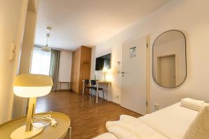 ein Wohnzimmer mit einem Bett und einem Spiegel in der Unterkunft Airport Messe Hotel in Düsseldorf