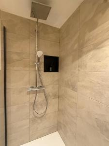 a shower with a shower head in a bathroom at Break Time Holidays Königsee, ein Juwel im Thüringer Wald in Niederdorla