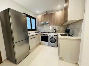 a kitchen with a stainless steel refrigerator and a dishwasher at Colina Smir par Immo Marina Vacances de Rêve C1-10 in Oulad Akkou