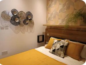 Un dormitorio con una cama con edredón amarillo y dos ventiladores. en Casa Luna beach side Luxurious comfy apt in center Paphos, en Paphos