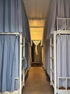 台东丛森民宿的走廊里挂着蓝色窗帘，摆放着双层床。