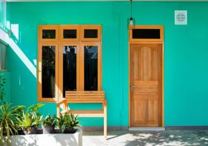 呼拉Exclusive Seaside 3-Bedroom Home的绿色建筑,设有木门和长凳