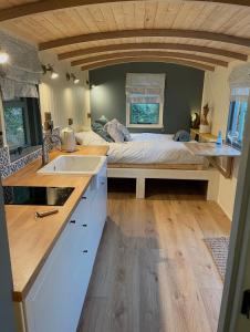 a kitchen with a bed and a sink in a room at Cornwall Shepherds Hut - Hot Tub & Cosy Log Burner in Saint Day