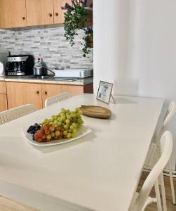 une assiette de raisins sur une table blanche dans une cuisine dans l'établissement IRIS Boutique Rooms, à Corinthe