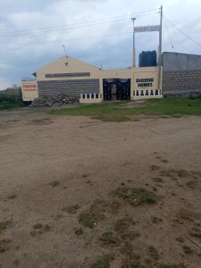 Un estacionamiento vacío frente a un edificio en EUGENE HOMES Guest House, en Gilgil