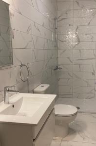 a white bathroom with a toilet and a sink at Fall In Paradise in Paralimni +33 photos