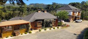 坎波斯杜若尔当Pousada Chales da Mantiqueira - Campos do Jordão的一栋房子的模型，车道上停着一辆汽车