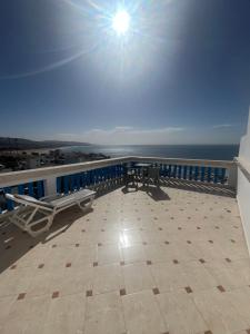 塔哈佐特Blue Beach Apartments的带桌子的阳台，可欣赏海景