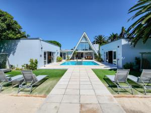 a house with a swimming pool and two chairs at Salt Boutique Guest House in Bloubergstrand