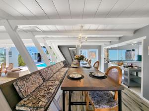 a dining room with a long table and chairs at Salt Boutique Guest House in Bloubergstrand