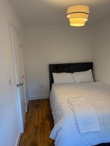 ein Schlafzimmer mit einem Bett mit schwarzem Kopfteil in der Unterkunft Comfortable double room with shared spaces in Longbridge