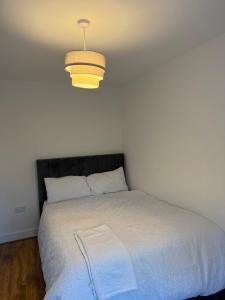 ein Schlafzimmer mit einem Bett mit einer Lampe darüber in der Unterkunft Comfortable double room with shared spaces in Longbridge