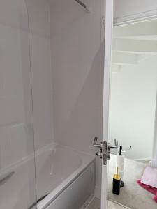 ein weißes Badezimmer mit Badewanne und Dusche in der Unterkunft Comfortable double room with shared spaces in Longbridge