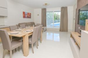Un comedor con mesa y sillas de madera. en Quaint, Central Ground floor 2 Bed 2 Bath apartments at Little Oaks, en Pembroke