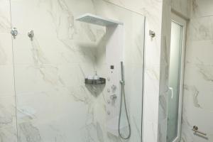 Un baño con ducha con puerta de cristal en Quaint, Central Ground floor 2 Bed 2 Bath apartments at Little Oaks, en Pembroke 6 fotos más