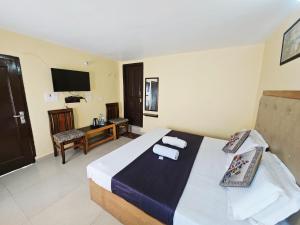 a hotel room with a bed and a television at SmartHill Bloom-Mountain View in Dalhousie