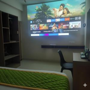una habitación con una pantalla grande en la pared en Elegant Residency, en Coimbatore
