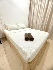 a bed with two brown shoes sitting on it at 7 STAY#3 - 1 Room for 2 Pax at Kuala Berang -Best Travelers Stay in Kuala Berang