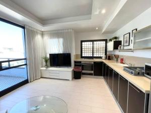 cocina con fregadero y TV. en 2Bedroom Suite 7 with shelter, en Tel Aviv