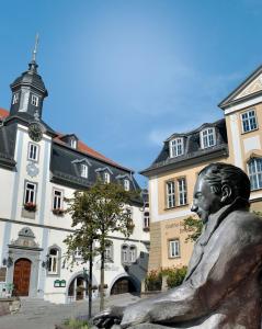 a statue of a man sitting in front of a building at Break Time Holidays Königsee, ein Juwel im Thüringer Wald in Niederdorla +34 photos