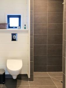 a bathroom with a toilet and a window at Elegant New Cottage On Quiet Woodland Site in Nykøbing Sjælland