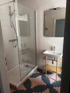 une salle de bain avec douche et lavabo dans l'établissement Hôtel Kempf, à Colmar