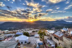 una vista de una ciudad con la puesta de sol en el fondo en Mountain Top Views -204- נופי פסגות, en Safed