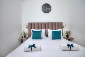 Un dormitorio con una cama con almohadas azules y un reloj. en Mountain Top Views -204- נופי פסגות, en Safed