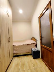 Una pequeña habitación con una cama y una puerta corredera. en Jermuk Mini Apartment, en Jermuk