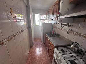 a small kitchen with a stove and a refrigerator at 2 Ambientes Gascon in Mar del Plata +2 photos