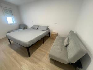 a bed and a couch in a room at Céntrico apartamento muralla 2 in Lugo