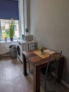 a kitchen with a table and chairs and a microwave at Stadtnah an der Förde 75 in Flensburg