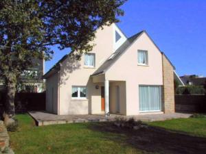 a white house with a tree in a yard at Maison spacieuse à Carnac - 8 pers, jardin clos, proche plage, Wifi, garage, petit animal accepté - FR-1-477-50 in Carnac