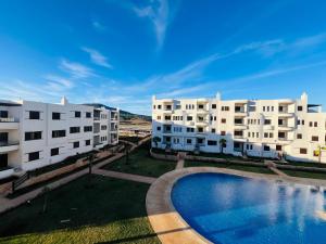 a view of two apartment buildings with a swimming pool at Colina Smir par Immo Marina Vacances de Rêve B1-10 in Oulad Akkou