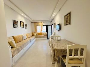 a living room with a couch and a table at Colina Smir par Immo Marina Vacances de Rêve B1-10 in Oulad Akkou