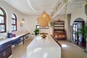 una cocina con una gran mesa blanca en una habitación en Oceana Beachfront Lux 6BR Retreat Villa Private Yoga Shala, en Mal País