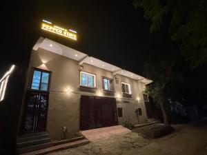 AyodhyaPepper Stayz in Ayodhya near Ramjanmabhoomi的晚上，一栋建筑的侧面挂着招牌