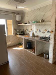a kitchen with a counter and a stove in it at Immeuble Elmo plage Mirleft in Mirleft +58 photos