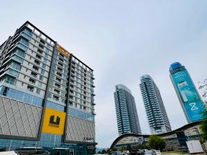 two tall buildings with cars parked in front of them at Clouds View Executive Serviced Apartments Fronting Centaurus Mall Islamabad in Islamabad