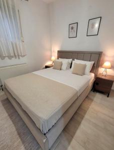 a bedroom with a large bed with white sheets and pillows at Center River Apartment in Florina