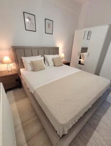 a bedroom with a large bed with white sheets and pillows at Center River Apartment in Florina