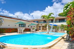 a swimming pool in front of a house at Pousada Shalom Beach in Maragogi