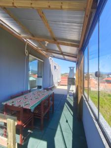 um pátio com uma mesa e algumas janelas em pousada vó cida em Palhoça